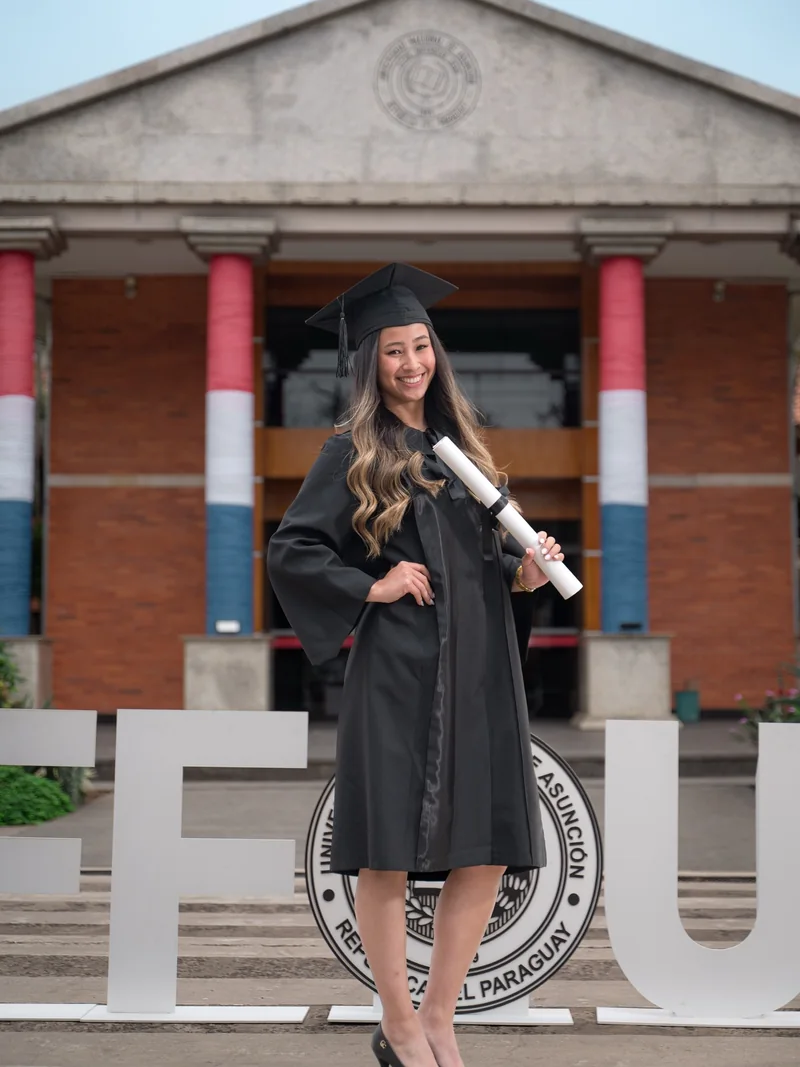 Graduada sentada en la escalera de la universidad