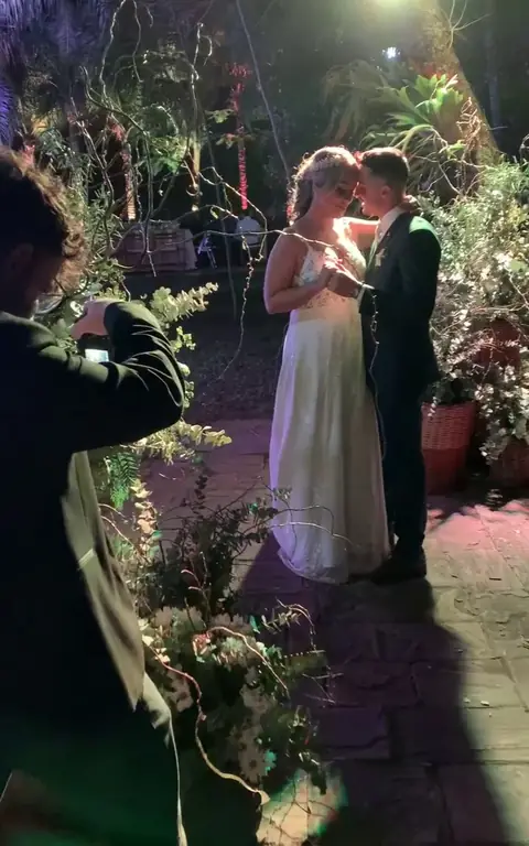 Diego fotografiando a los novios de noche en un jardín
